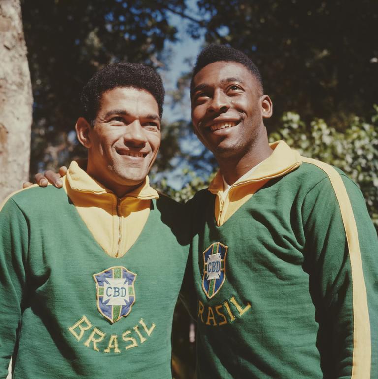 Brazilian footballer Pele (Edson Arantes do Nascimento) posed on right with Garrincha (Manuel Francisco dos Santos) both wearing Brazil national team uniform in 1962. (Photo by Popperfoto via Getty Images/Getty Images)